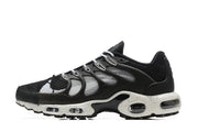 Side view of black and white Nike Air Max TN Plus sneakers with a speckled midsole