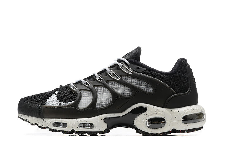 Side view of black and white Nike Air Max TN Plus sneakers with a speckled midsole