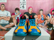 Front view of Nike basketball sneakers with blue laces, bright orange and blue patterned uppers, and black tongues.