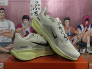 Angled view of the gray Nike sneakers displaying the Swoosh, laces, textured upper, and contrasting midsole.