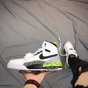 Side view of a white, black, gray, and bright green Air Jordan Legacy 312 sneaker