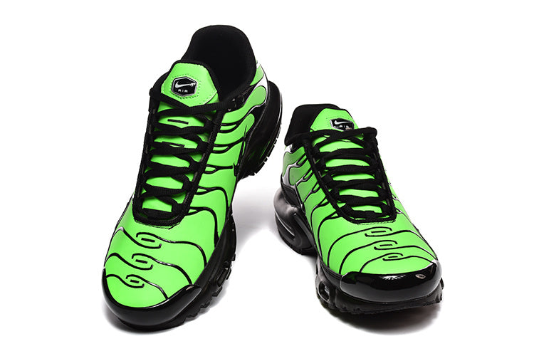 Pair of Nike Air Max Plus sneakers in vivid green and black, viewed from the front.