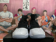 Front view of the pair of white and black high-top basketball shoes with perforated toe areas.