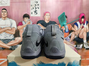 Rear view of gray Nike basketball shoes with black Swoosh logos and speckled heel panels