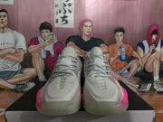 Front view of the white and gray Nike sneakers with pink side and sole accents.