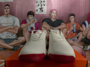Front view of white Nike sneakers with red toe outsoles, white laces and padded collars.