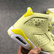 Close-up of the lateral side showing perforated panels, a yellow heel detail, and the visible heel cushioning window.