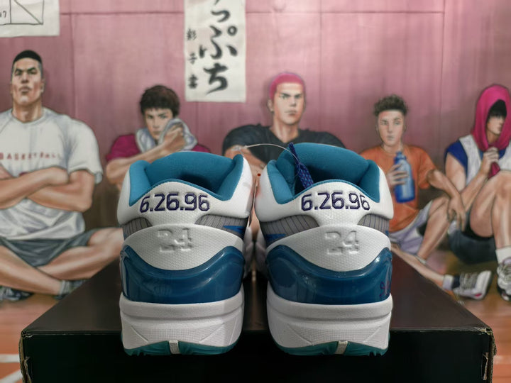 Rear view of white, blue, and teal basketball sneakers showing the “6.26.96” heel detail and translucent teal heel sections.