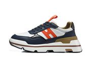 Side profile of a navy, white, and orange Hermès sneaker with a layered sole.
