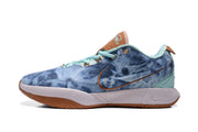 Side profile of a blue Nike sneaker with a mottled upper, brown outlined swoosh, white midsole, and gum-colored outsole.
