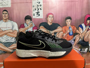 Side view of a black Nike basketball shoe with green detailing and a speckled midsole.
