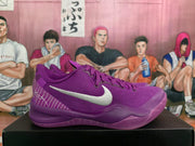 Side profile of a purple Nike basketball sneaker showing the silver Swoosh, heel line artwork, and layered purple sole.