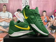Pair of green Nike basketball sneakers with yellow Swoosh branding displayed on a black shoebox.