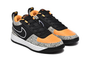 Three-quarter front view of the black, white, and orange sneakers with black laces and spotted toe panels.