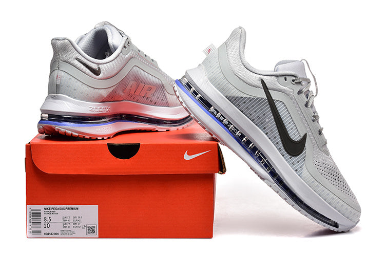 Light grey Nike Pegasus Premium shoes beside an orange Nike box