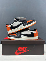 Pair of black, orange and white Jordan low-top sneakers arranged on a branded shoebox.