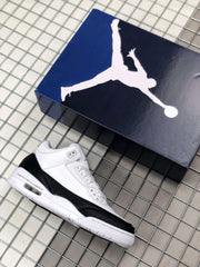 White and black Fragment x Air Jordan 3 sneaker beside a Jordan shoebox.