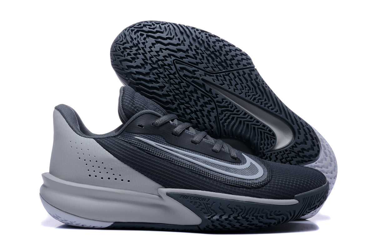 Nike Precision 7 basketball shoe in black and gray, shown with its patterned outsole facing up.