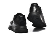 Rear and outsole views of black sneakers with chunky tread