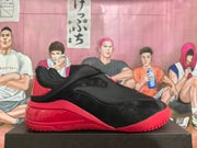 Single black and red sneaker shown from the side with a zippered upper, padded collar, and molded red sole.