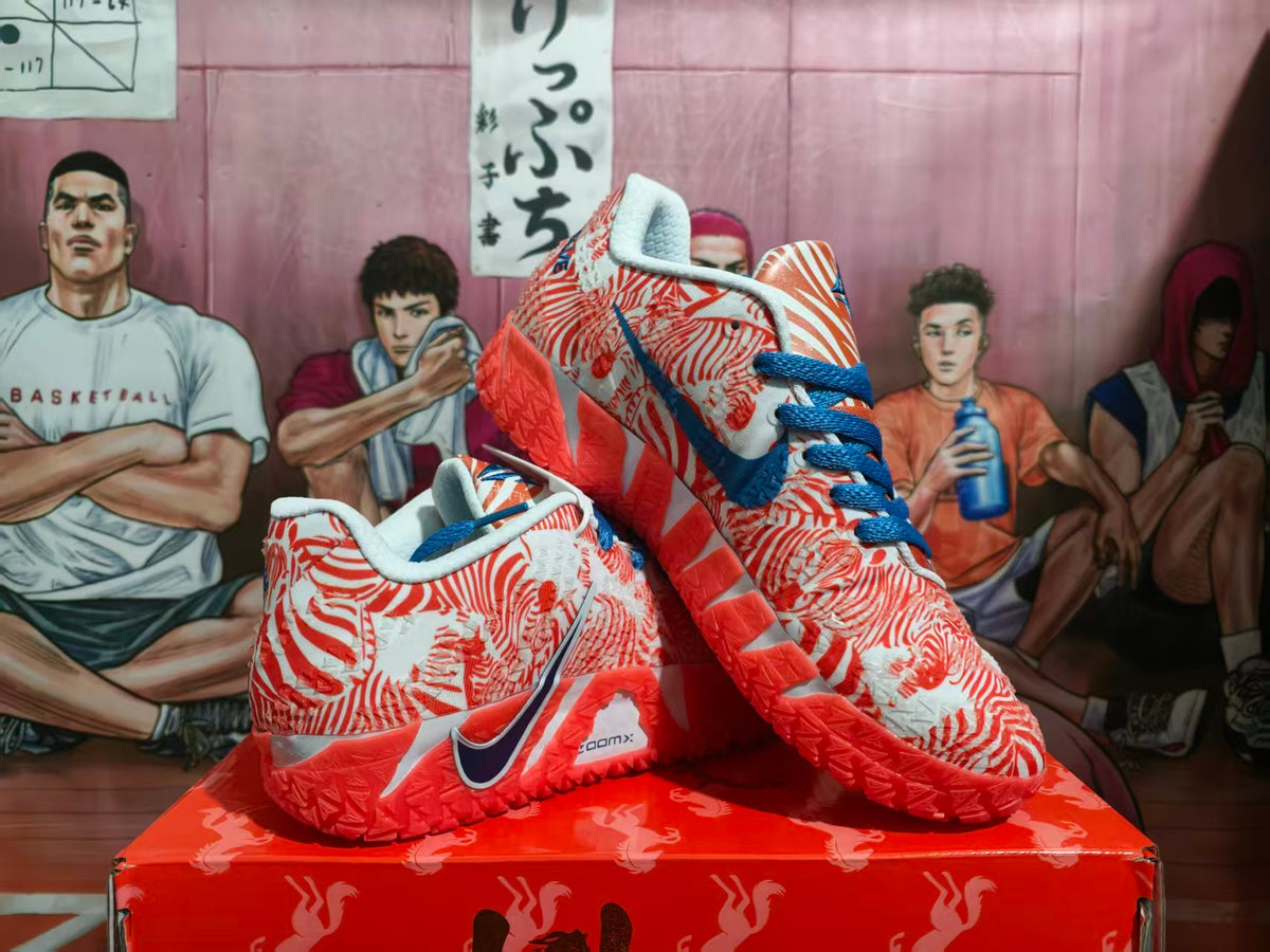 Pair of orange and white Nike basketball sneakers with blue laces and a patterned upper displayed on an orange shoebox.