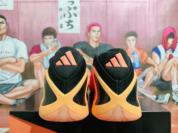 Rear view of black Adidas basketball shoes with coral-pink and gold-toned accents.