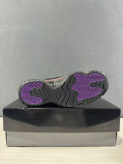 Bottom view of the sneaker showing the dark outsole and purple traction areas.