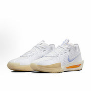 Pair of white Nike basketball sneakers with cream-colored outsoles and orange accents.