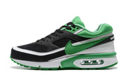 Side view of a black and green low-top sneaker with white trim and a visible heel air unit.