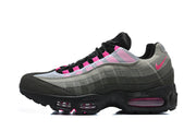 Side view of a Nike Air Max 95 TT sneaker with grey panels and pink accents.