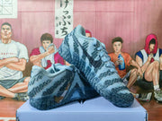 Angled view showing the blue knit-style upper, patterned overlays, laces, and dark sculpted outsole.