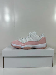 Side view of a pink and white low-top Jordan sneaker displayed on a white box.