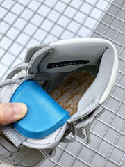 Close-up of the sneaker collar, gray laces, blue tongue insert, and patterned insole.