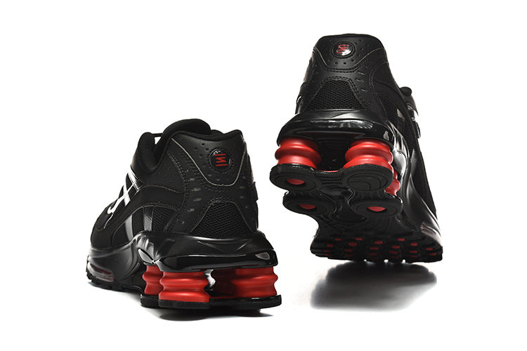 Rear and outsole views of black Nike Shox Ride 2 sneakers with red heel columns.