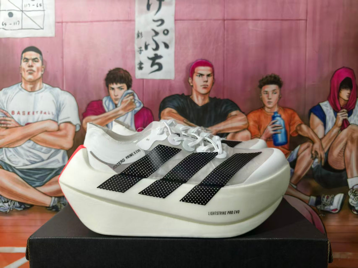 Pair of white adidas Adizero Prime X Evo sneakers with black three-stripe detailing displayed on a shoebox.