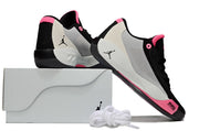 Black, pink and light gray Luka.77 sneakers arranged with a light-colored shoebox and white spare laces.