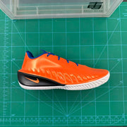 Side view of an orange Nike GT basketball shoe on a green measuring mat