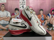 Angled view of the white Nike basketball shoes showing black Swoosh and red midsole