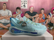 Side profile of a light blue basketball sneaker showing layered upper detailing and a blue decorative side cushioning panel.