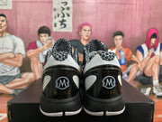 Rear view of black and white basketball sneakers showing Kobe and Gigi heel graphics.