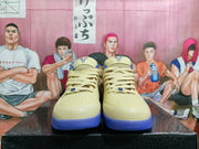 Front view of matching beige and blue basketball sneakers showing perforated toe boxes, laces, and tongue emblems.