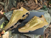 Pair of gold Kobe 5 shoes with the outsole traction pattern visible