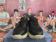 Front view of black Nike sneakers with textured uppers, padded tongues, black laces, and cream-colored soles.