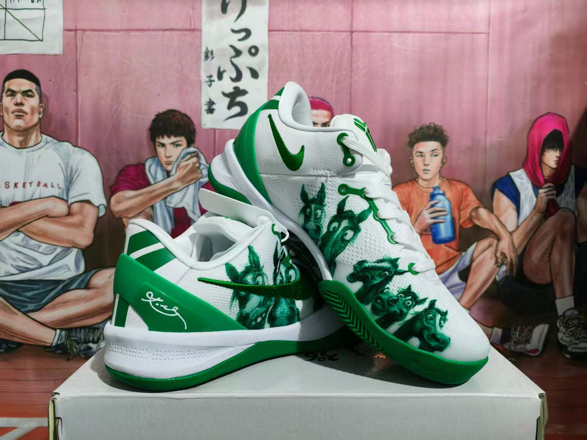 Pair of white and green Nike basketball sneakers displayed on a box, showing the side graphics, green outsole, and padded collars.