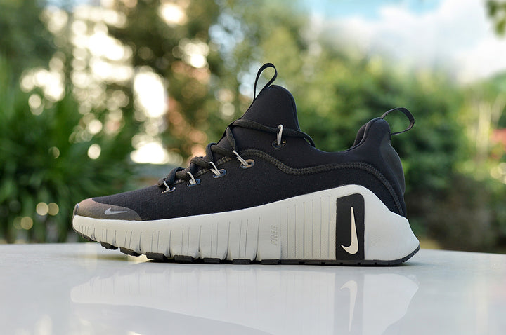 Side view of a black Nike running shoe with a white sculpted sole and black heel detail.