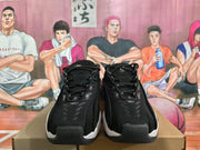 Front view of black Nike sneakers showing the lace-up upper, textured panels, and white midsole accents.