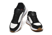 Front view of black and white lace-up sneakers with white soles.