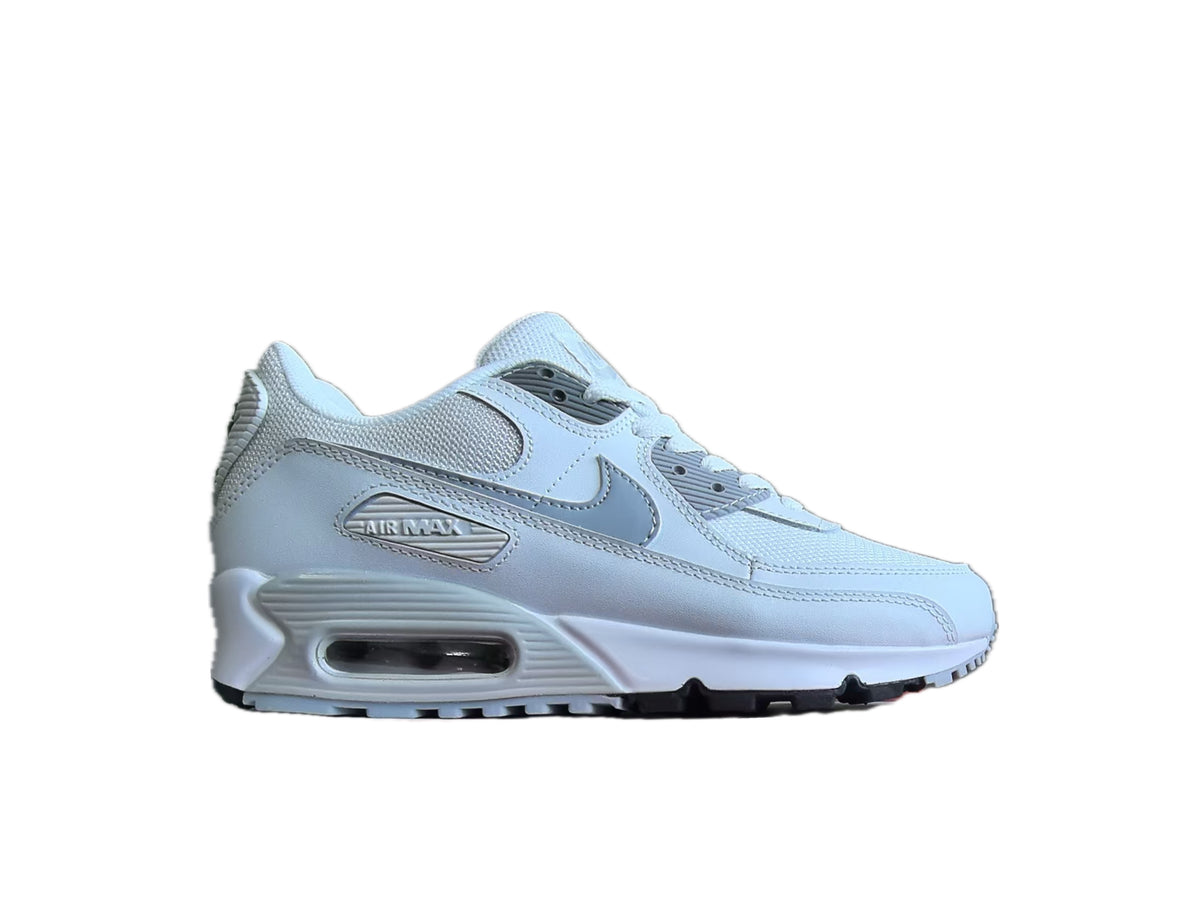 Side view of a white Nike Air Max 90-style sneaker with a visible Air unit and dark outsole