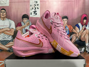 Pair of pink Nike basketball shoes shown at an angle, with gold-toned accents