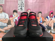 Front view of black and red high-top basketball sneakers with black laces, red tongues, and ankle straps.